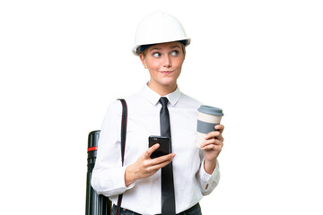 Young architect caucasian woman with helmet and holding blueprints over isolated background holding...