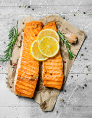 Grilled salmon fillet with slices of fresh lemon.