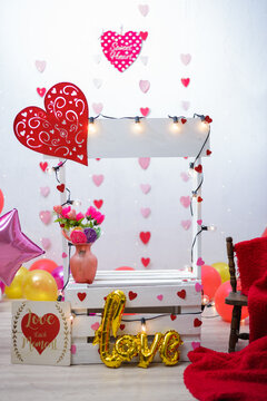 Kissing booth in photo studio for children's photo shoot. Photo studio decorated with balloons and hearts.