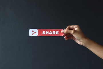 Hand holding printed paper with Share text and icon. Vlogger asking people to share their video on...
