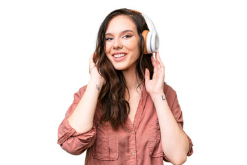 Fototapeta premium Young caucasian woman over isolated background listening music