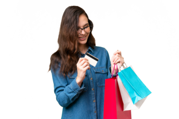Young caucasian woman over isolated background holding shopping bags and a credit card
