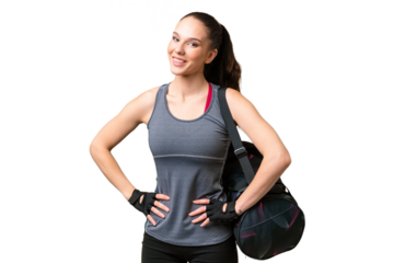 Young sport woman with sport bag over isolated background posing with arms at hip and smiling