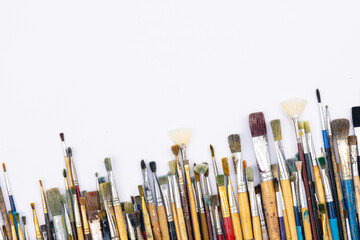 Fototapeta premium Many brushes for painting on a white background, top view.