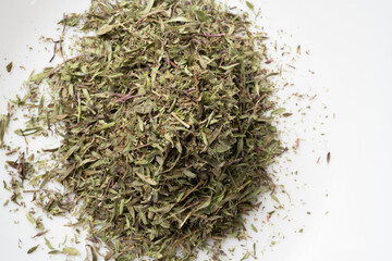 Pile of dried thyme leaves white background.