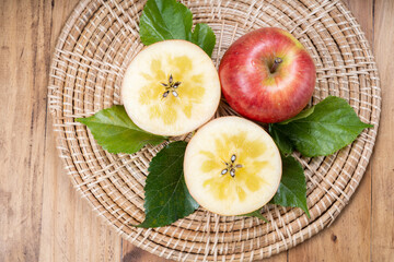 Red Kotoku Apple in the basket over green natural Blur background, Fresh Red Honey core Apple on bamboo mat.  