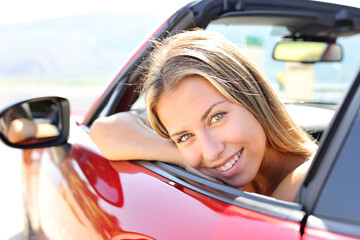 Happy convertible car driver looks at you