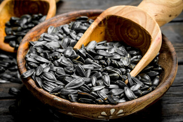 Sunflower seeds in bowl with scoop.
