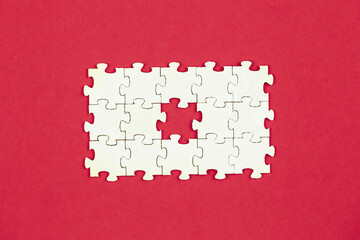 White puzzles on a red background, flat lay.