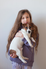 A ten-year-old girl is playing with a puppy. Terrier pet.
