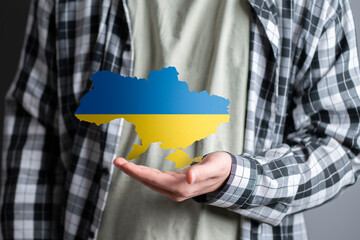 person holding ukranian map in blue and yellow colors