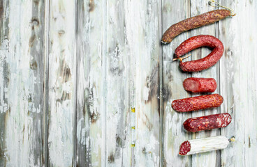 Assortment of different smoked salami with herbs and seasonings.