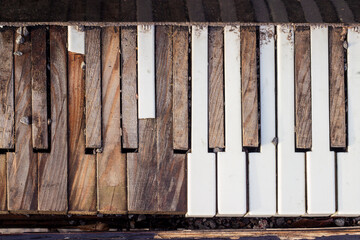 Old broken piano. Keyboard with broken, peeled piano keys.