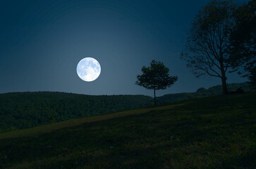 Beautiful scenery of big bright full moon over the mountains in the evening