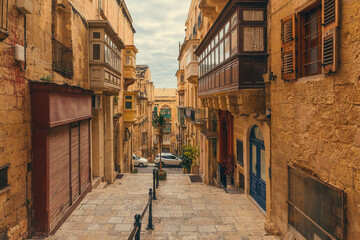 Old medieval narrow street with balconies on ancient houses in Valletta town, Malta with nobody
