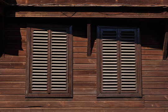 windows on the wooden facade in bulgaria. architectural retro elemet background