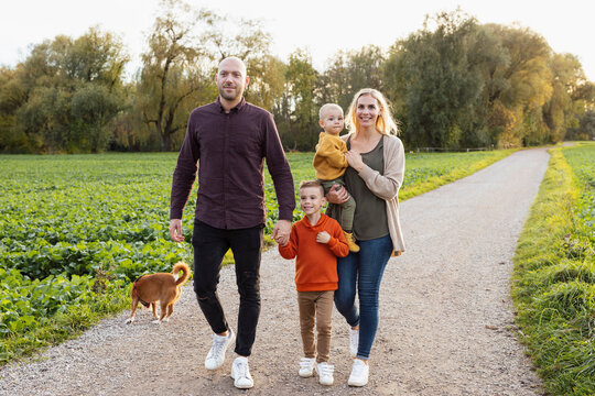 Happy Family Walking On Footpath In Nature