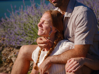 concept of embracing fresh air and engaging in outdoor activities. Couple of hipster Enjoy moment of happiness and love in lavender field in mountains. Love in lavender concept.