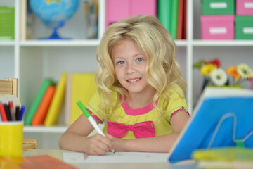 little girl studying at home at the table