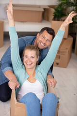 young couple have fun while moving to a new apartment