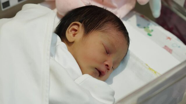 newborn baby laying in the infant bassinet basket at hospital