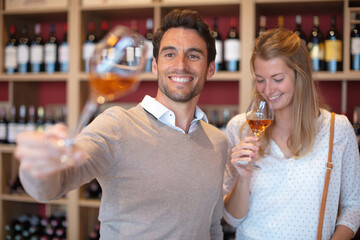 couple smelling bouquet of glass of wine in wine tasting