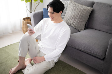 Man who inquires with a smartphone by checking White, easy to use for spring/summer-like image...