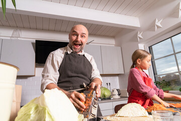 Happy father and daughter preparing healthy meal in kitchen at home