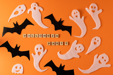 White ghosts and bat craft for Halloween party. Wrapping paper ghost on orange background top view. Cartoon creepy Whisper. DIY hand made. Set boo characters. Word wooden letter phrase.