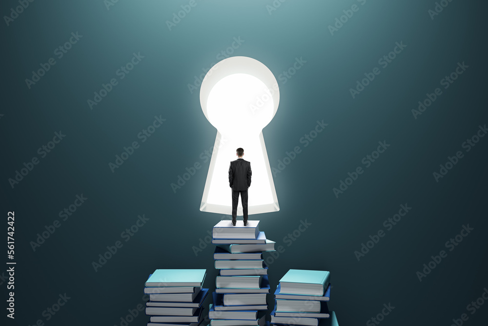 Aufkleber Business success and development concept with businessman back view looking at the window in form of key hole staying on book stacks on dark background