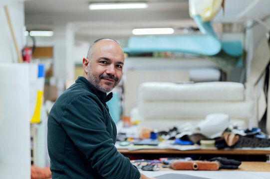 Smiling craftsman in upholstery workshop