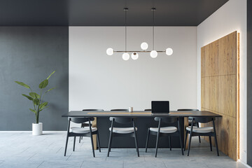 Front view on dark conference table with laptop and chairs around on concrete floor in spacious meeting office room with backlit wooden decoration and white and grey wall background. 3D rendering