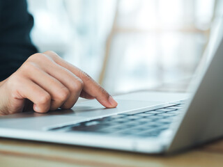 Close-up finger of business person in suit touch on touchpad on laptop computer. Working on notebook, business technology concept. Control your digital world with just your fingertips.