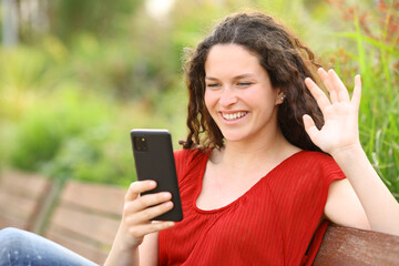 Happy woman having phone video call greeting