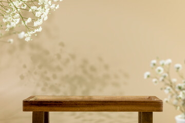 Wooden empty podium for food, products or cosmetics on natural beige background with white flowers...