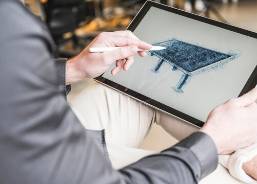 Young businessman drawing solar panel on tablet PC at office