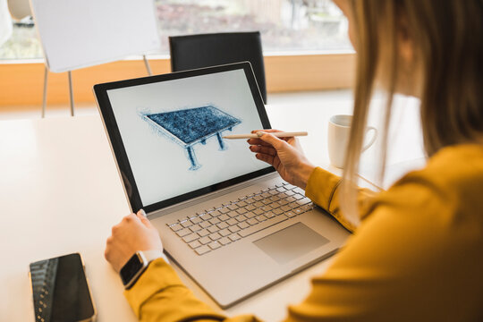Young businesswoman drawing solar panel on laptop with digitized pen