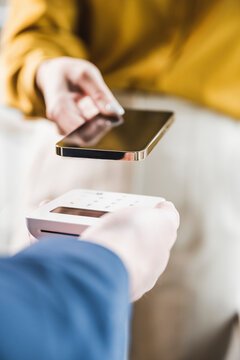 Hand of businesswoman paying through smart phone on credit card reader