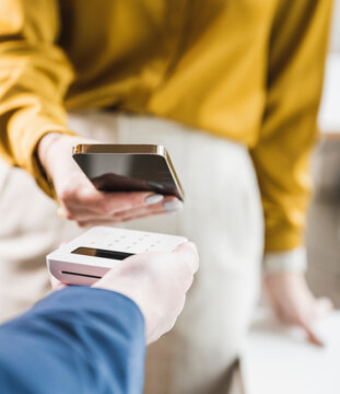 Businesswoman paying through smart phone on credit card reader