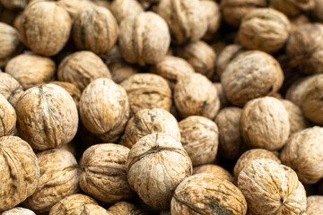 Lots of walnuts background, freshly harvested crop. Healthy food concept.