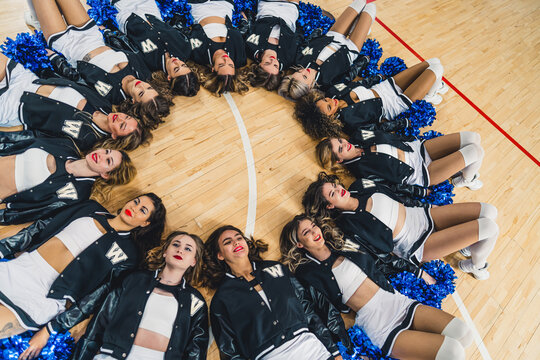 High angle shot. Cheerleading squad lying on the floor in a circle. Sport concept. High quality photo