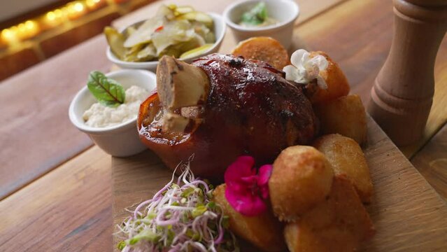 Traditional Polish cuisine - golonka - roasted pork knuckle served in modern way with crispy oven-baked potatoes and beansprouts. High quality 4k footage