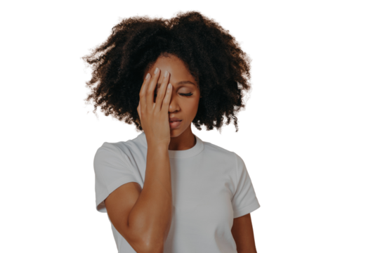 Dark skinned female covering face with hand and feeling anxiety or depression against beige wall