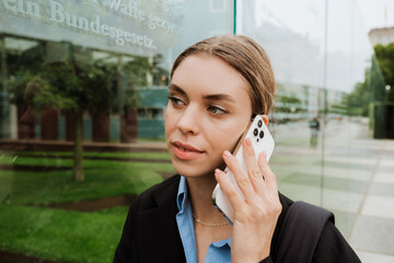 Young woman talking on cellphone while walking through city street