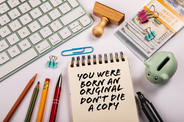 You Were Born An Original Don't Die a Copy. Text on a notepad