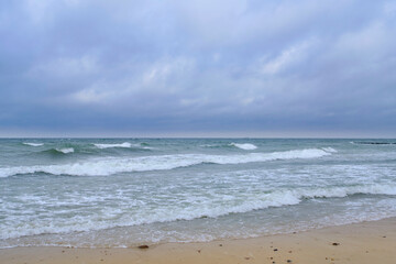 Rolling waves on sandy beach Baltic Sea.