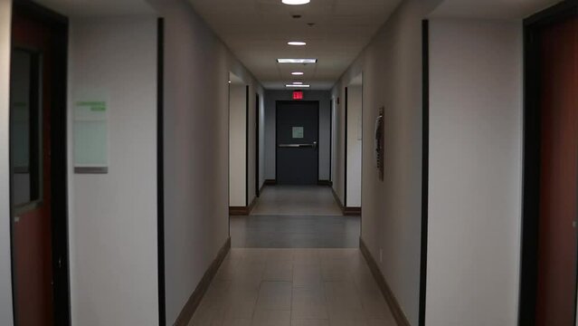 The bright interior of the corridor of a modern hotel. The point of view is a walk through an empty hotel corridor. First-person shooting, a man walking down the corridor.