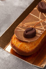 Eclair with custard, chocolate icing and chocolate coffee beans