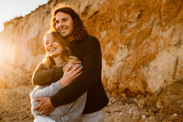 Beautiful couple embracing while spending time at sunny beach