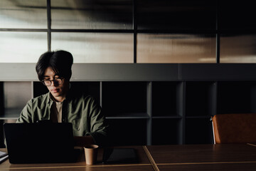 Young business man working on laptop while sitting in office